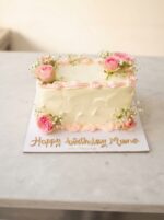 Rectangular birthday cake with pink flowers and baby breath flowers