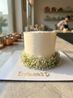 amazing engagement cake with baby breath flowers and ring toppers side view